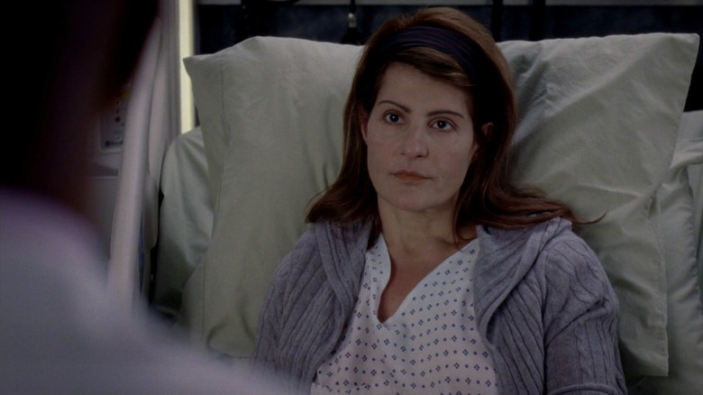 Karen in hospital gown, looking on