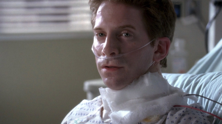 Nick Hanscom with bandage around his neck in hospital bed