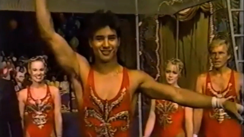 Mario Lopez in red circus outfit taking a bow in front of Jennie Garth and Maureen Flannigan on Circus of the Stars