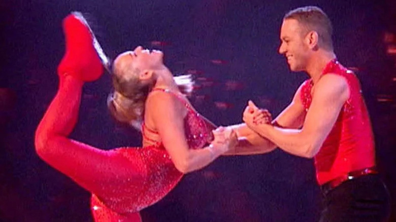 Jennifer Ellison kicking skate back behind her head with partner on Dancing on Ice