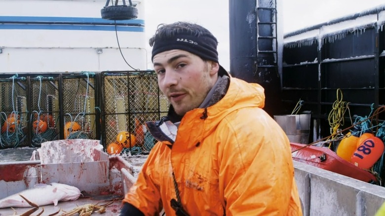 James Gallagher in bright orange jacket on fishing boat in Deadliest Catch