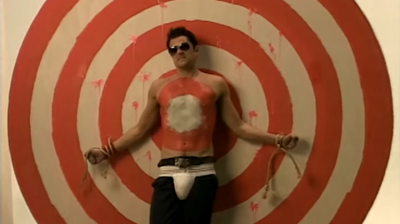 Johnny Knoxville in sunglasses with codpiece attached to bullseye in Jackass
