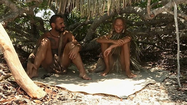 Two contestants sitting in shade in Naked and Afraid