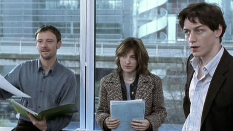 Cal, Della, and Dan stand together in the office with papers in State of Play.