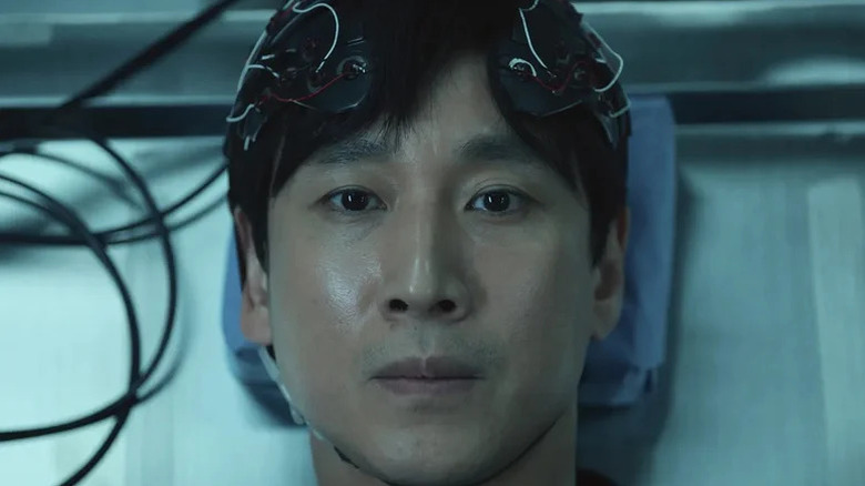 Close up of Lee Sun-kyun as Sewon Koh with wired device on his head in Dr. Brain