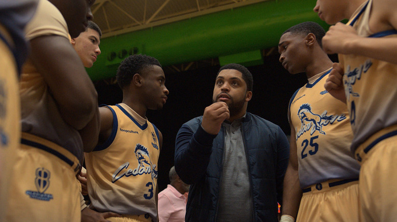 O'Shea Jackson Jr. as Ike Edwards, surrounded by basketball players in yellow jerseys in Swagger