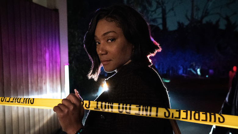 Tiffany Haddish as Detective Danner standing behind yellow crime scene tape in The Afterparty