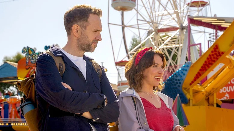 Rafe Spall as Jason and Esther Smith as Nikki standing at carnival in front of rides in Trying