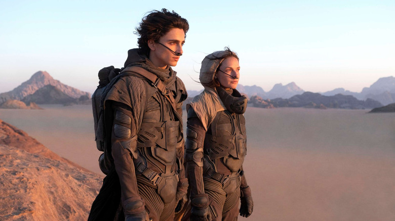 Paul (Timothee Chalamet) and Jessica (Rebecca Ferguson) survey the desert in Dune.
