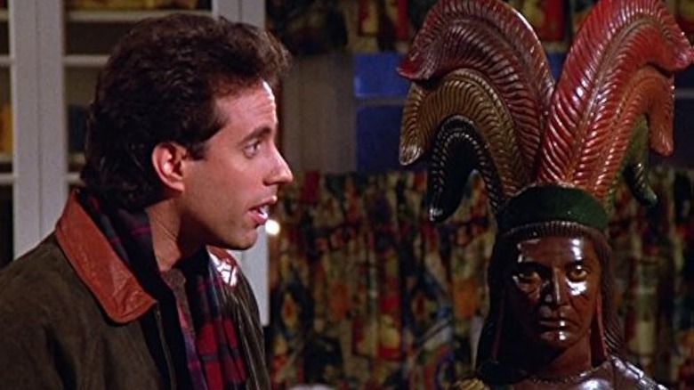 Jerry Seinfeld as Jerry looking at a cigar store Indian statue in Seinfeld