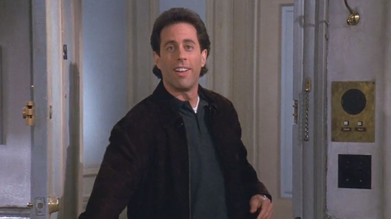 Jerry Seinfeld addresses the audience while stepping out of his apartment on Seinfeld
