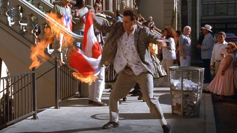 Cosmo Kramer (Michael Richards) holds a burning Puerto Rican flag in Seinfeld