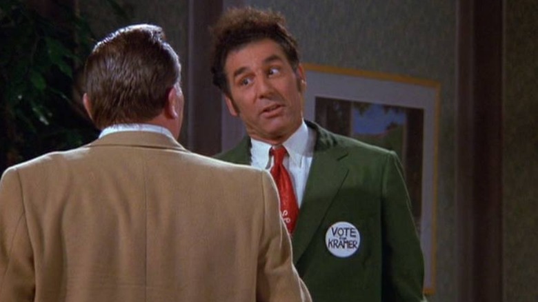 Cosmo Kramer (Michael Richards) shakes a constituent's hand while wearing a campaign button in Seinfeld