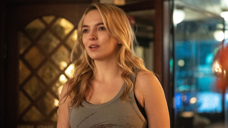 Jodie Comer as Villanelle crying with blood stains on her shirt in Killing Eve