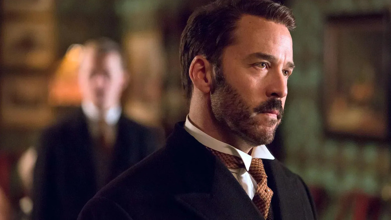 Harry Gordon Selfridge (Jeremy Piven) stands sternly in a parlor in Mr. Selfridge