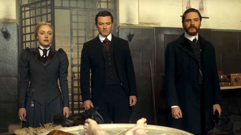 Sara Howard (Dakota Fanning), John Schuyler Moore (Luke Evans), and Laszlo Kreizler (Daniel Brühl) survey a corpse in The Alienist