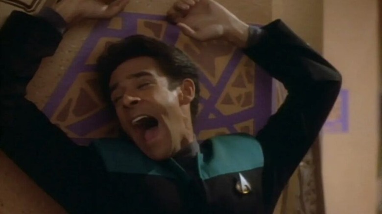 Julian Bashir (Alexander Siddig) screams while up against a wall in Star Trek: Deep Space Nine