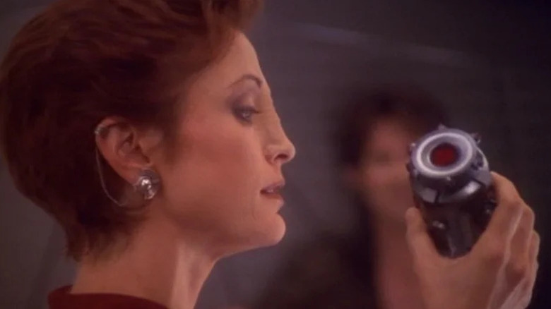 Kira Nerys (Nana Visitor) holds a strange device in Star Trek: Deep Space Nine