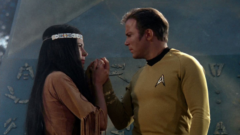 Miramanee (Sabrina Scharf) tenderly holds the hand of Jim Kirk (William Shatner) on Star Trek: The Original Series