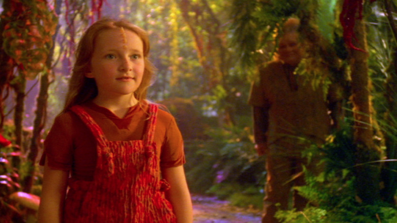 Naomi Wildman (Scarlett Pomers) and Neelix (Ethan Phillips) stand in a lush jungle in Star Trek: Voyager