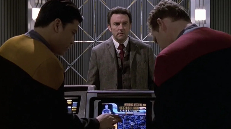 A stunned Michael Sullivan (Fintan McKeown) watches Harry Kim (Garrett Wang) and Tom Paris (Robert Duncan McNeill) work in Star Trek: Voyager