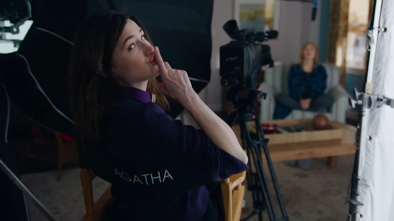 Kathryn Hahn as Agatha Harkness, sitting in a director's chair in WandaVision.