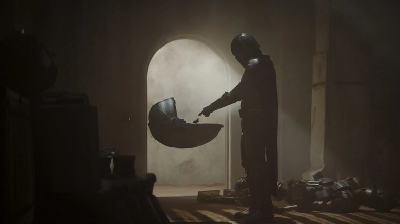 Din Djarin reaches out to Grogu in The Mandalorian.
