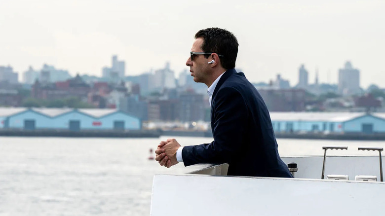 Jeremy Strong as Kendall Roy, looking out into the water wearing earbuds in Succession.