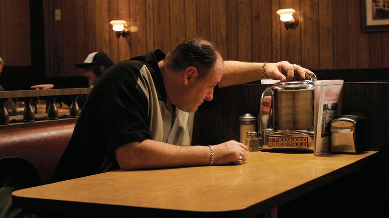 James Gandolfini as Tony Soprano, flipping through a table jukebox in The Sopranos.