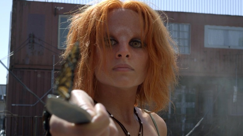 Stephanie Leonidas as Irisa Nyira holding a knife and looking at butterfly in Defiance