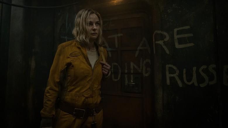 Rebecca Ferguson's Juliette Nichols wearing an orange jumpsuit and walking on a dark hallway on Silo