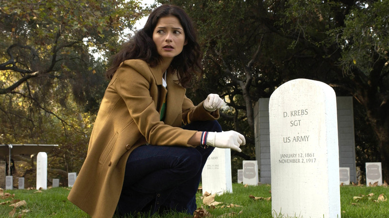 Jill Hennessy as Dr. Jordan Cavanaugh sits next to a tombstone in Crossing Jordan