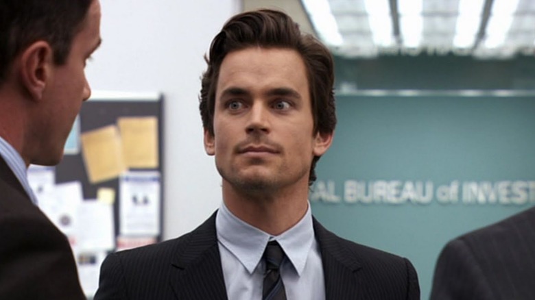 Matt Bomer as Neal Caffrey stands between two agents in White Collar