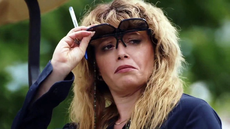 Charlie Cale (Natasha Lyonne) looks skeptically under sunglasses in Poker Face