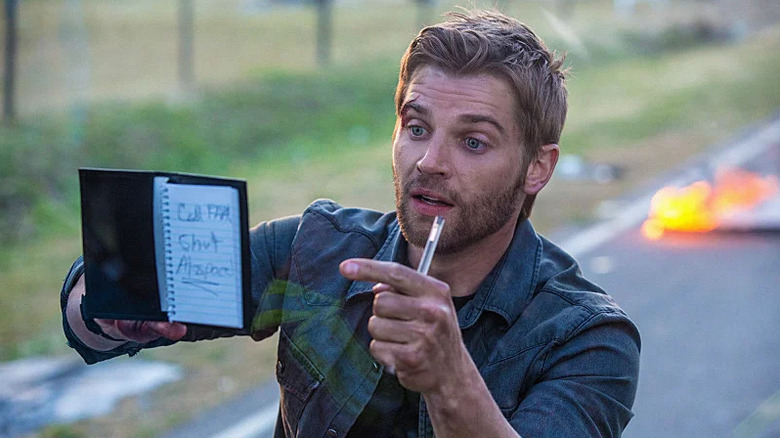 Barbie holding a note against the wall of the dome on Under the Dome