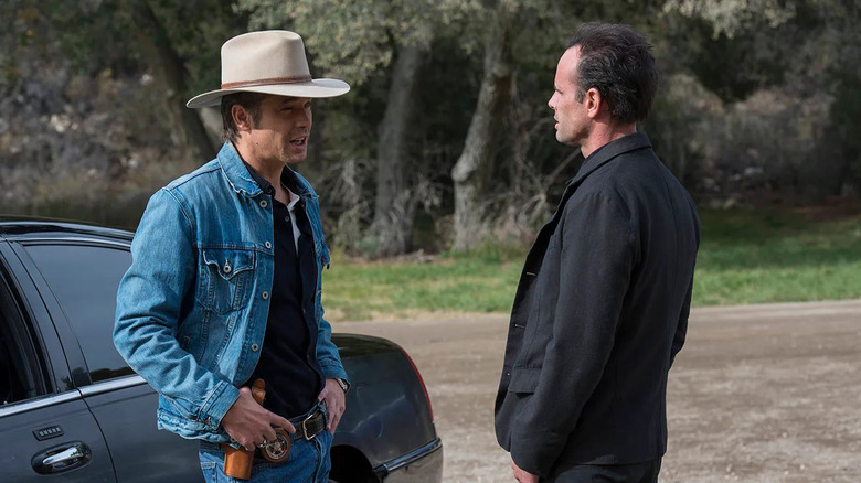 Raylan Givens (Timothy Olyphant) speaks to Boyd Crowder (Walton Goggins) beside a parked car in Justified