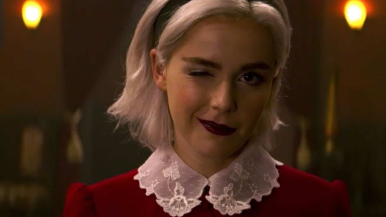 Sabrina Spellman (Kiernan Shipka) winks at the camera in Chilling Adventures of Sabrina