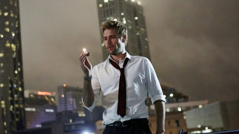 John Constantine (Matt Ryan) lights a lighter on a cloudy rooftop in Constantine