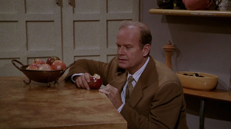 Frasier (Kelsey Grammer) holding an apple on Frasier