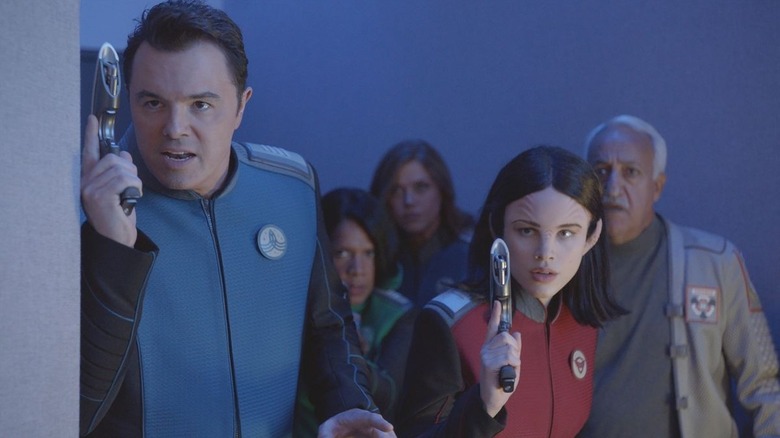 Captain Ed Mercer (Seth MacFarlane) and Alara (Halston Sage) holding blasters on The Orville