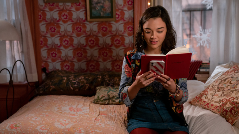 Lily sitting on her bed reading the shared notebook in Dash & Lily