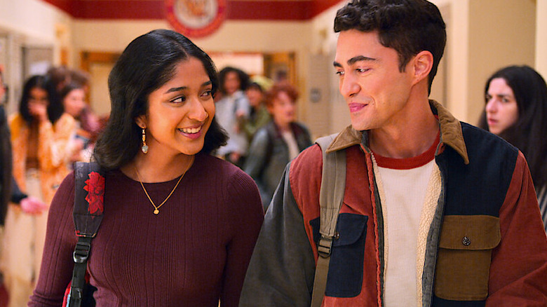 Devi smiling and walking with Paxton down the high school hallway in Never Have I Ever