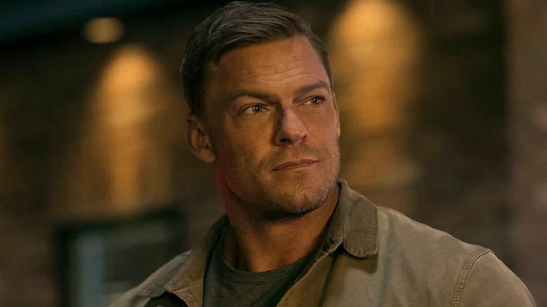 Alan Ritchson as Jack Reacher smirks in Reacher