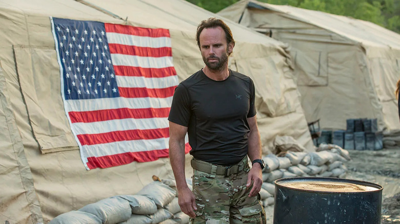 Walton Goggins as Rip Taggart stands in front on an American flag in SIX