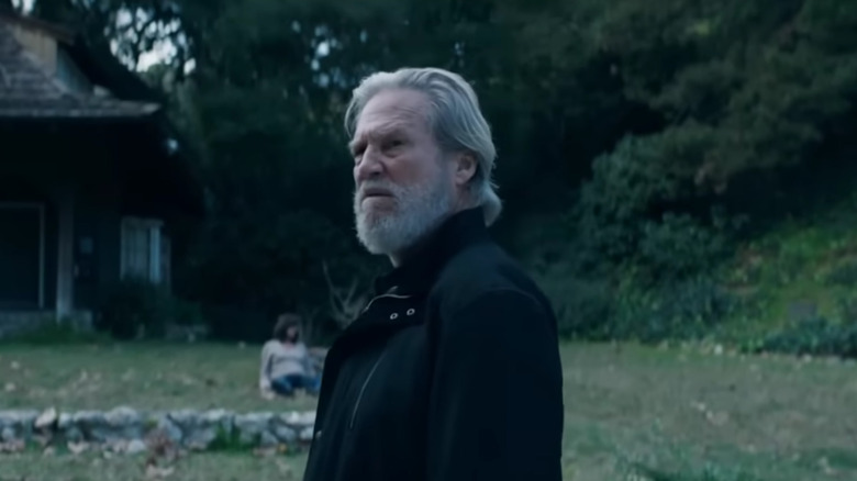 Jeff Bridges' Dan Chase looking serious at the front yard of a house on The Old Man