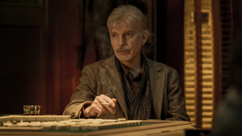 Billy McBride (Billy Bob Thornton) smokes a cigarette at a mahjong table in Goliath