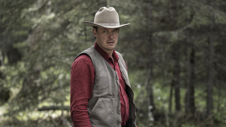 Joe Pickett (Michael Dorman) stands outside in the woods in Joe Pickett