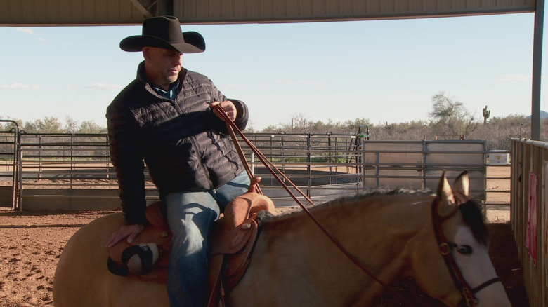 A cowboy leans back on his horse in The Last Cowboy