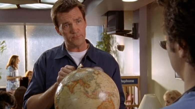 Neil Flynn as the Janitor holding a globe in front of Zach Braff as J.D. (face not visible) in Scrubs