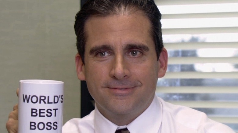 Michael Scott (Steve Carell) holds up a mug stating "World's Best Boss" in The Office (2005)